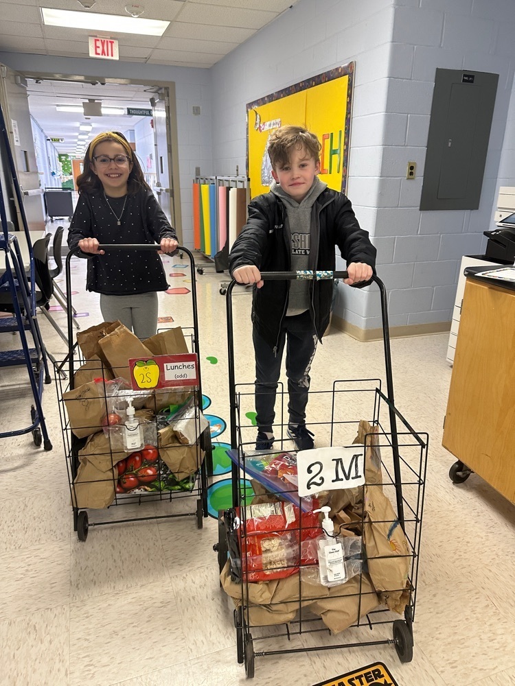 two students using carts to collect donated lunches 