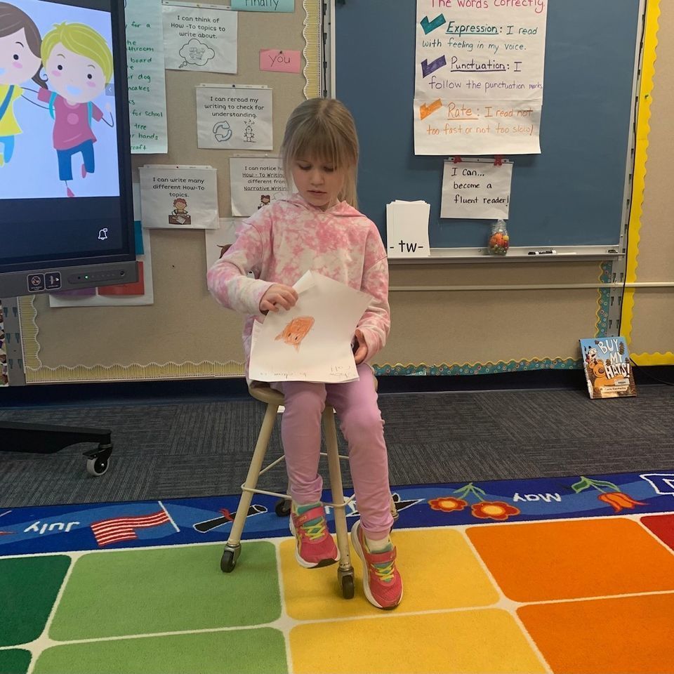 students sitting on stool sharing writing assignment