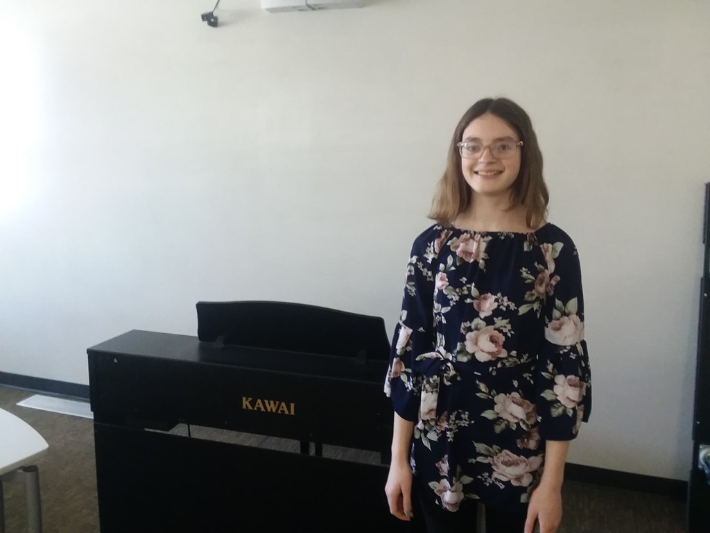 student standing by piano