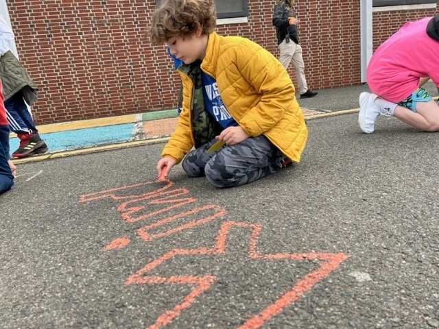 Wilson student chalking the word kind