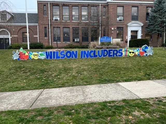 Wilson Includers sign in front of the school building