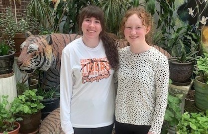 Lauren Kneer and Sydney Ziemba in front of tiger statues and plants