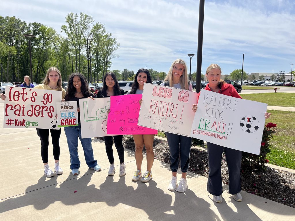 Legacy soccer supporters with signs wishing boy teams luck in playoffs