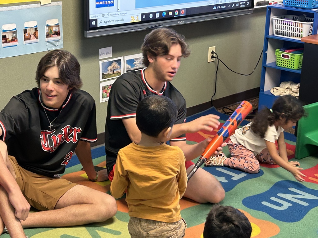 Legacy baseball players at Jones ES teaching students in Ms. McWain's class about baseball equipment