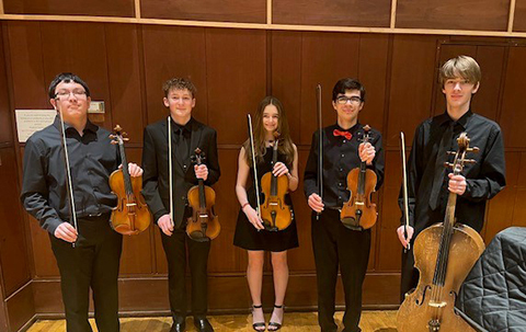 students posing with their viloins and cello