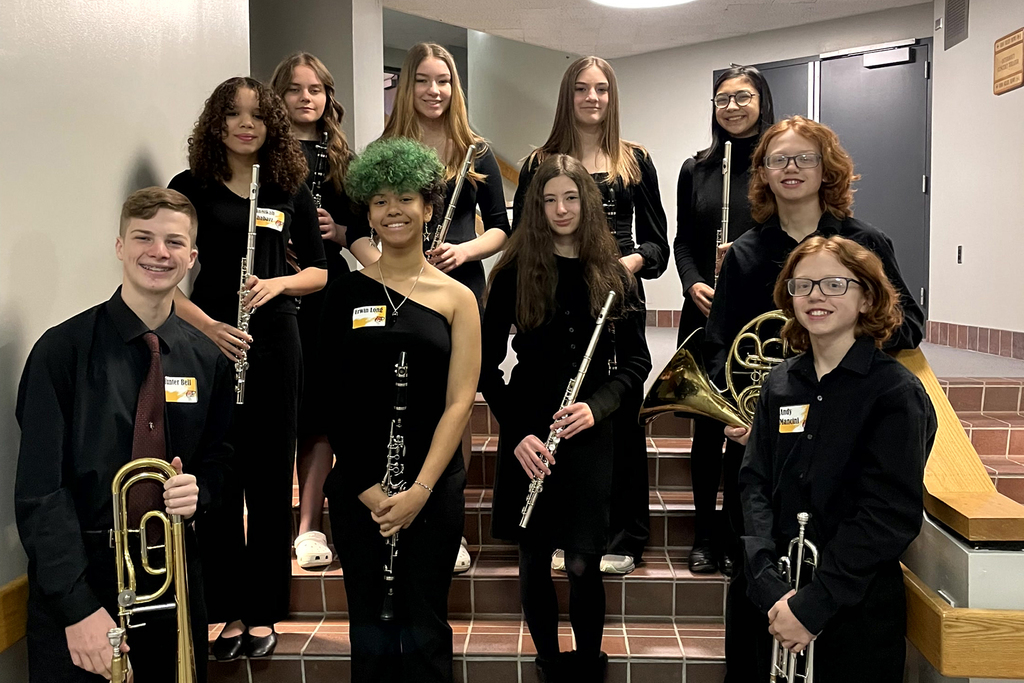 students from band posing with their clarinets, flues, trumpets, and trompones