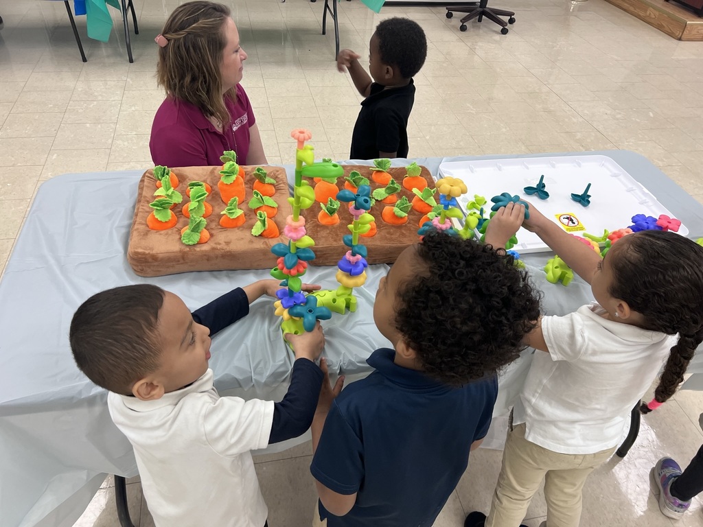 three dark haired children playing with colorful toys on a table