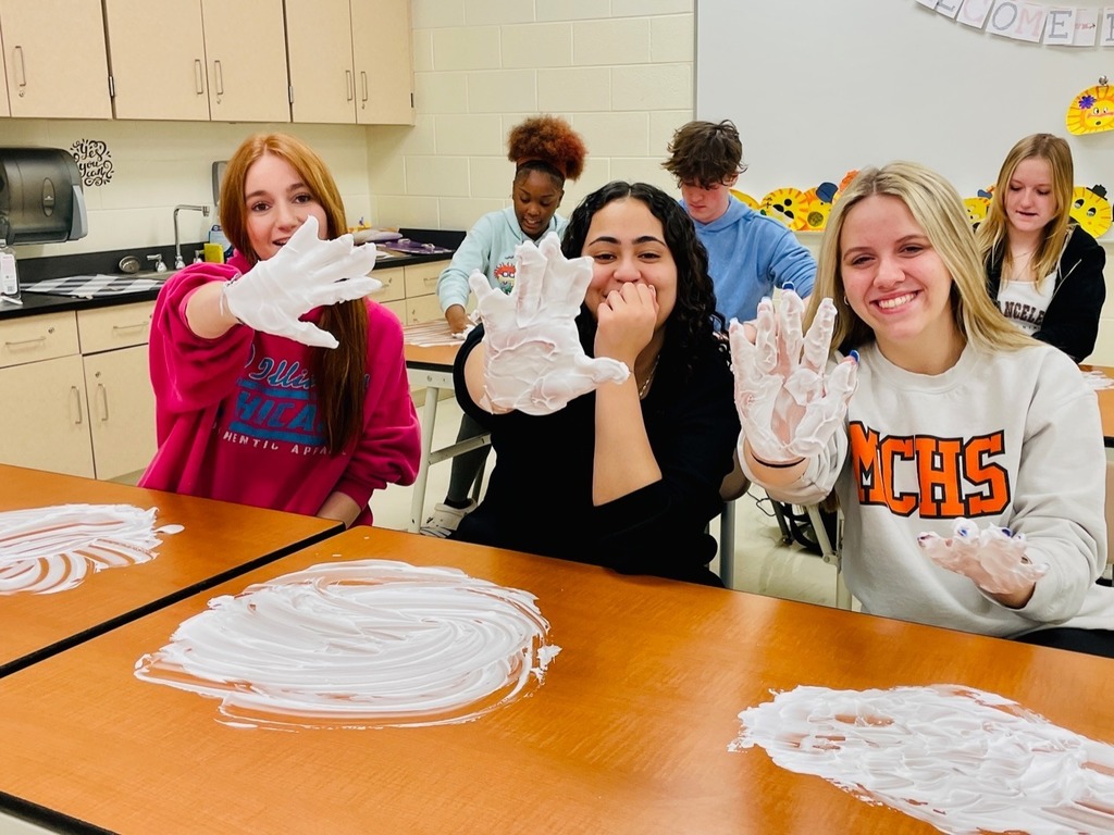 students with shaving cream on their hands smiling