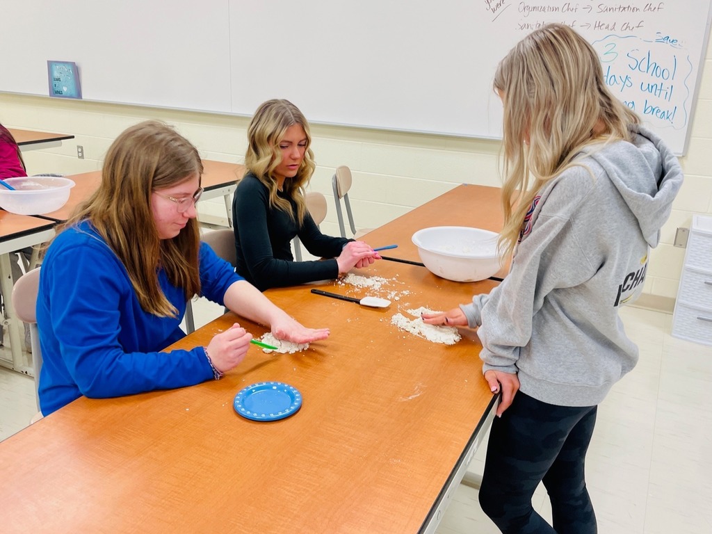 students smearing shaving cream on the table and using pencils to draw in it