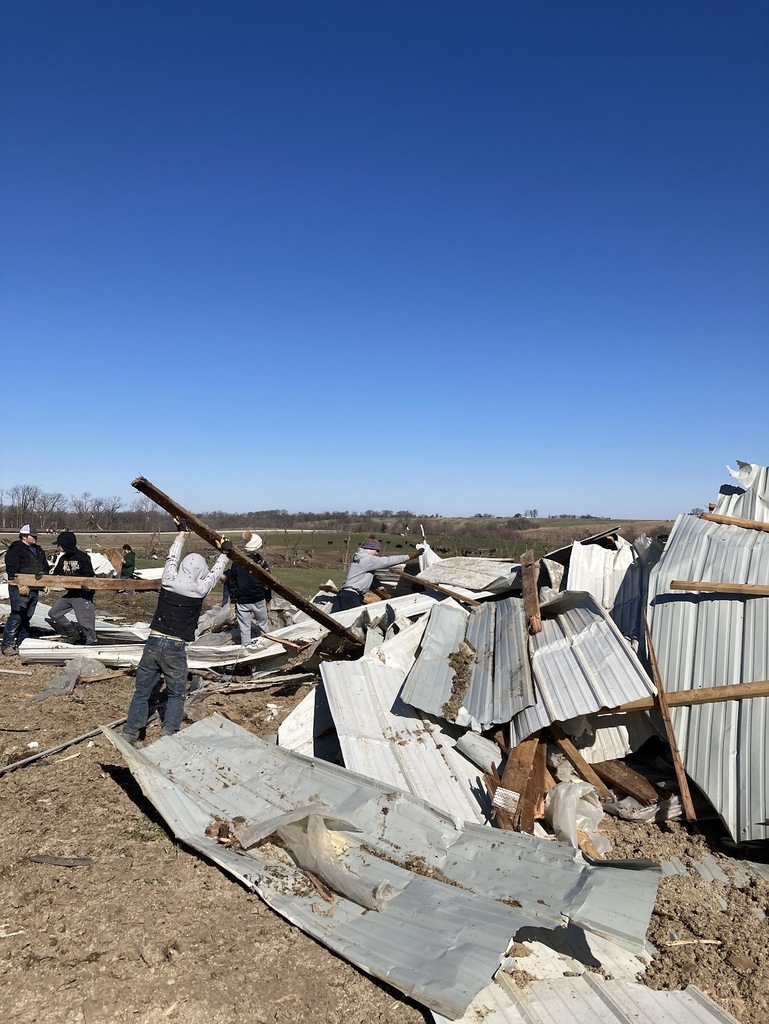 Students working to clean up tornado damage debris
