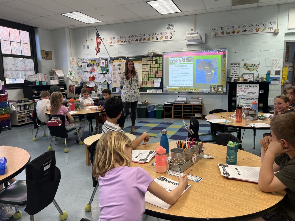 Students having a discussion with their teacher in 2nd grade classroom.