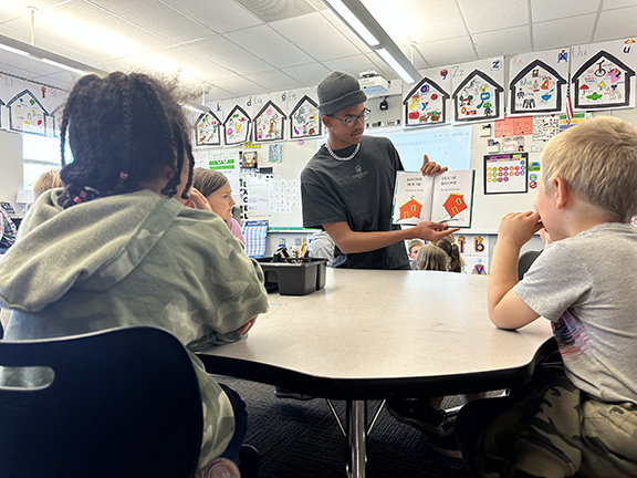 prom king candidate reading to Blackmore students