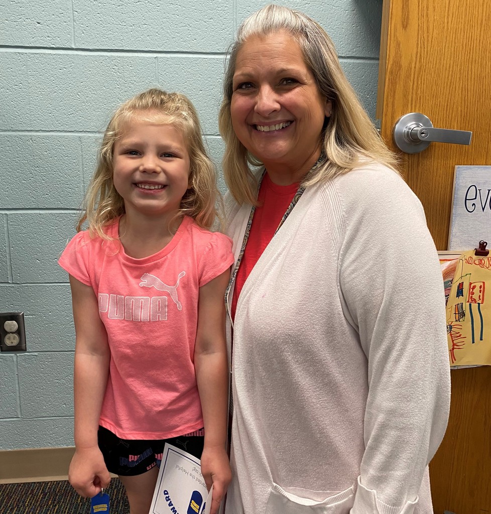 Child holding certificate with her teacher