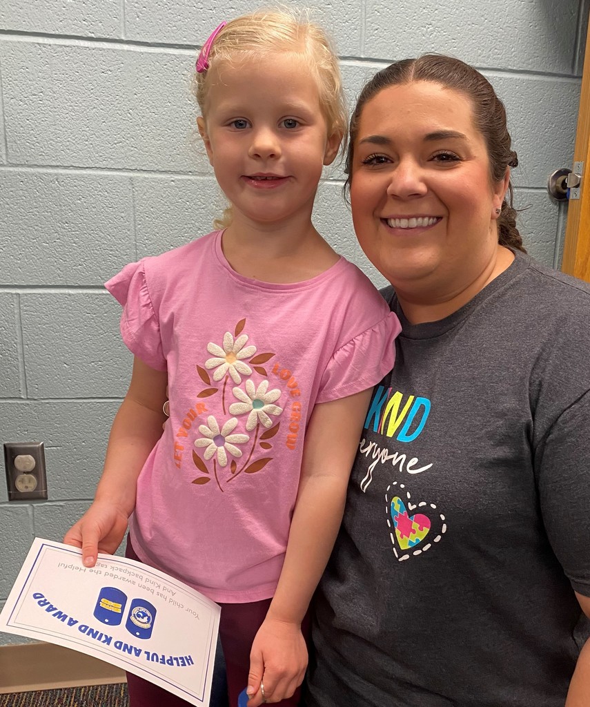 Child holding certificate with her teacher