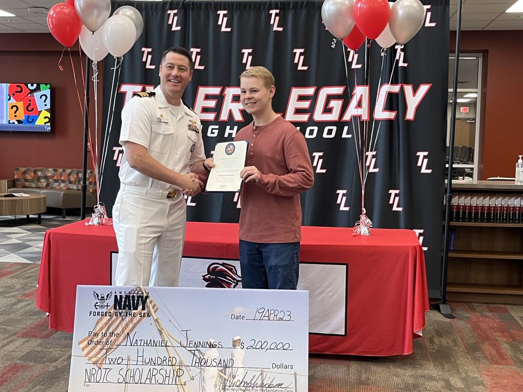 Legacy student Nate Jennings with the Navy and his scholarship check