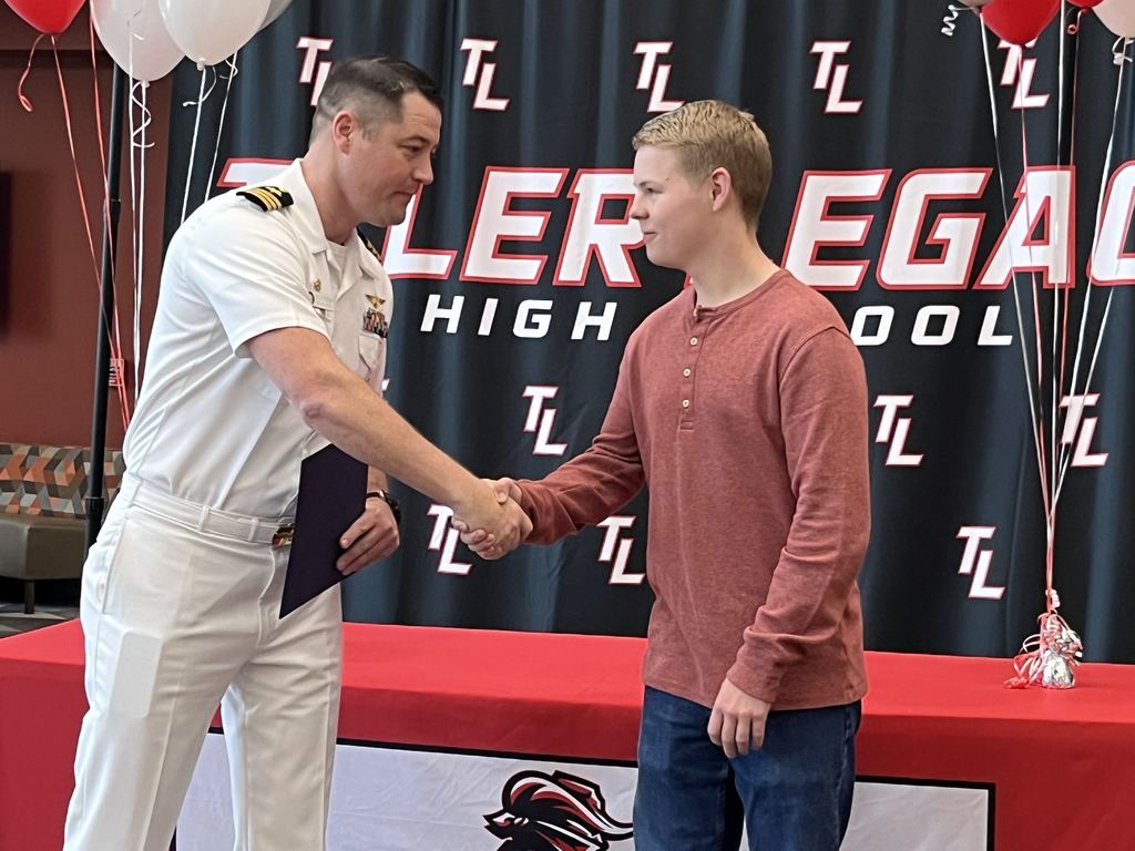 Nate Jennings mid hand shake with the Navy representative during his scholarship ceremony