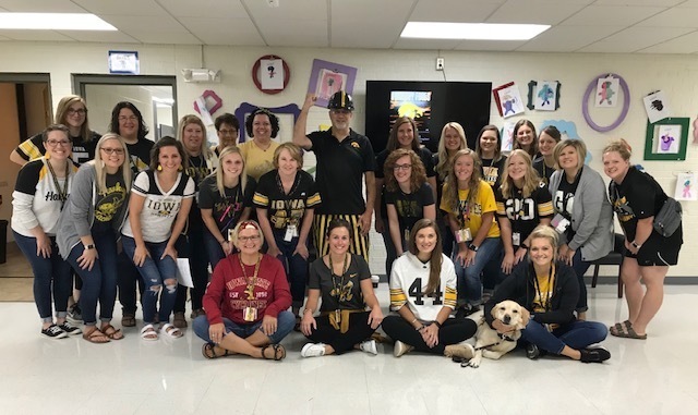 Staff gather for a picture dressed up in University of Iowa or Iowa State gear