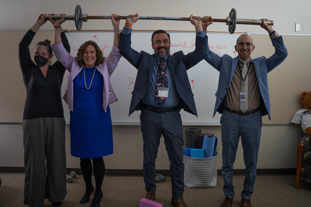 SFPS BOE President Sarah Boses, US DOE Deputy Secretary of Education Cindy Marten, New Mexico Secretary of Education Dr. Arsenio Romero and SFPS Superintedent Hilario "Larry" Chavez lifting a weight bar to symbolize "Raising the Bar"