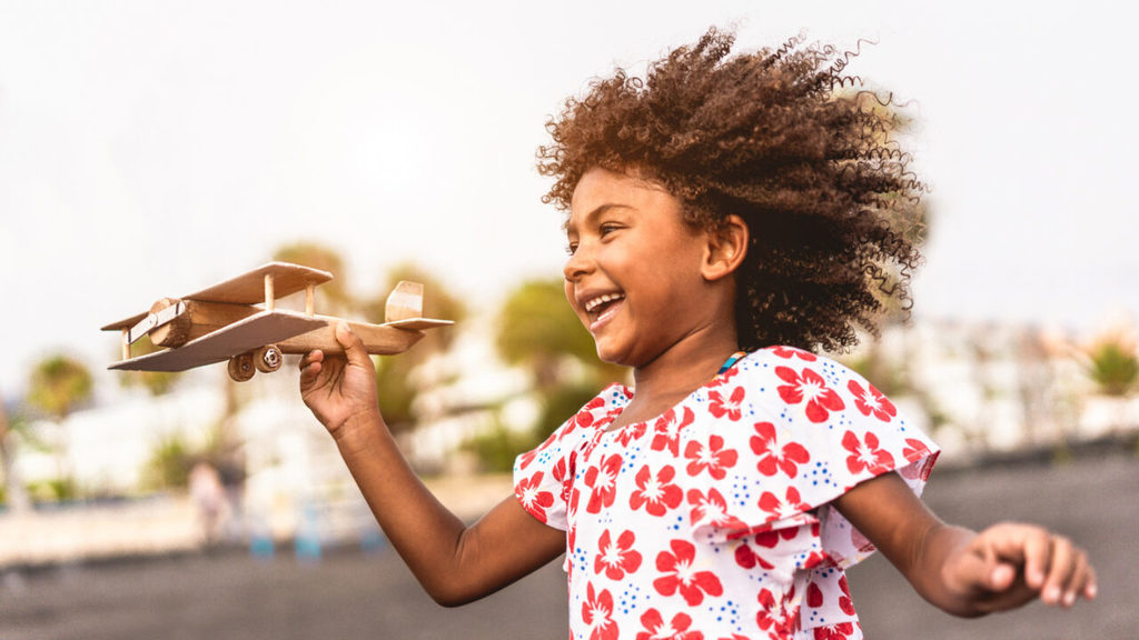 Girl flying toy airplane