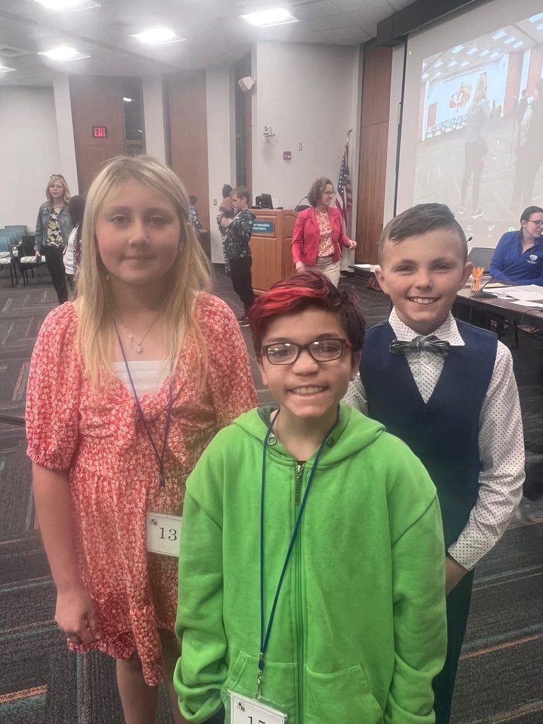 3 students standing in the room at the spelling bee