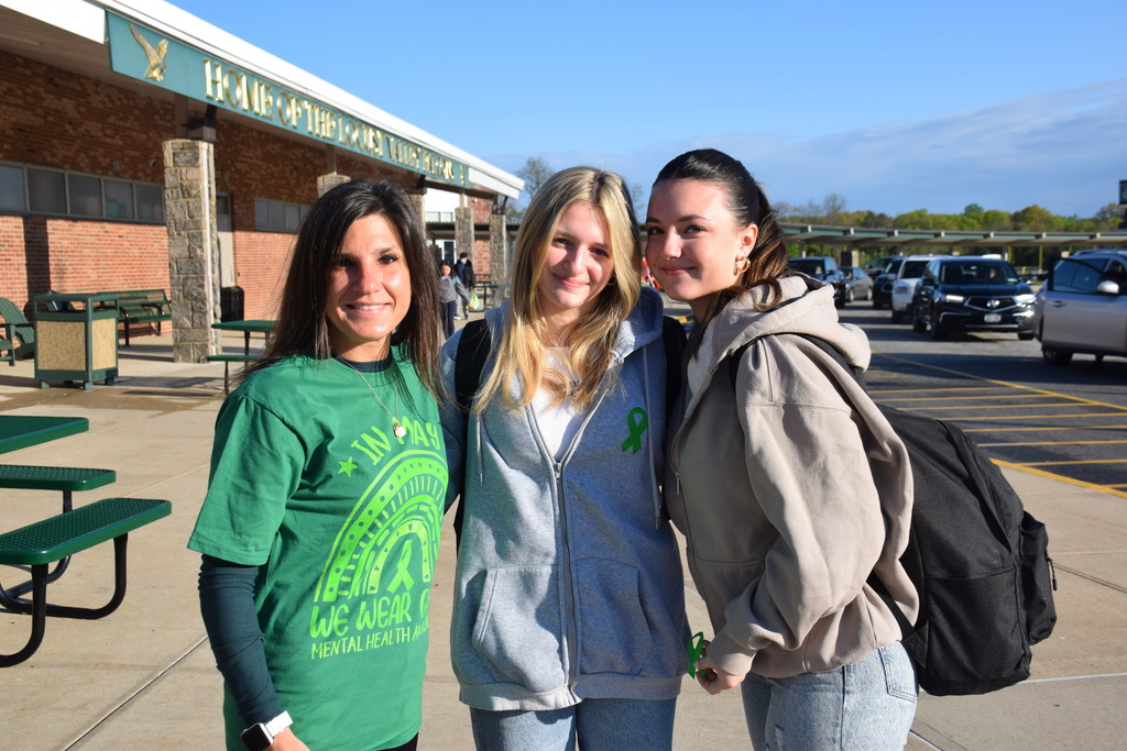 Locust Valley Middle School Counselor Kelley Grassi gives high school students Isabelle and Ryann Croke green ribbons for Mental Health Awareness Month on May 1.