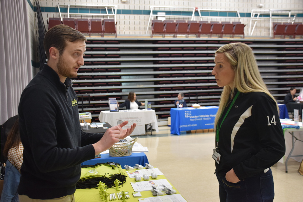 Locust Valley Central School District Athletic Director Danielle Turner speaks with a representative from Jovia Financial Credit Union during the Staff Wellness Fair.