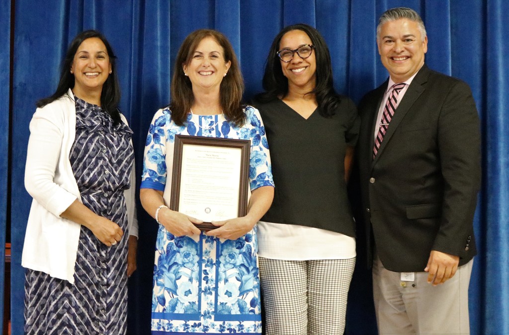 Wilson recipient of teacher award poses for picture with superintendent, principal and Board president