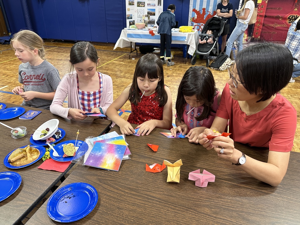 Students sitting an working on origami