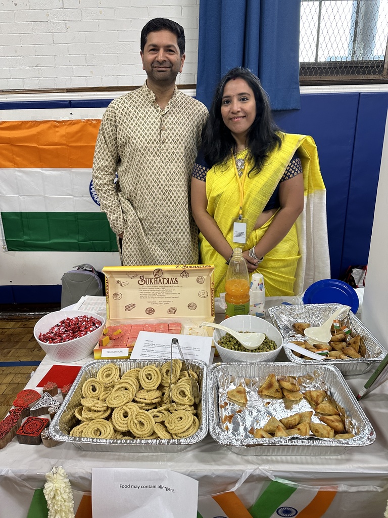 Two Wilson parent volunteers standing behind the display for India