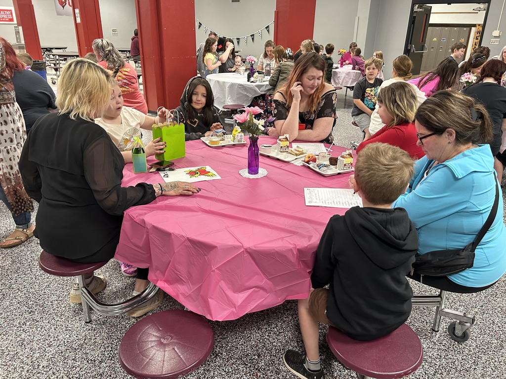 Parents and students sitting around the cafeteria tables