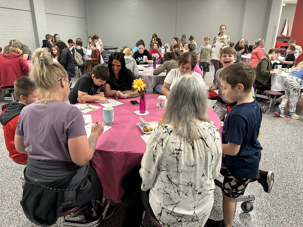 Parents and students sitting around the cafeteria tables