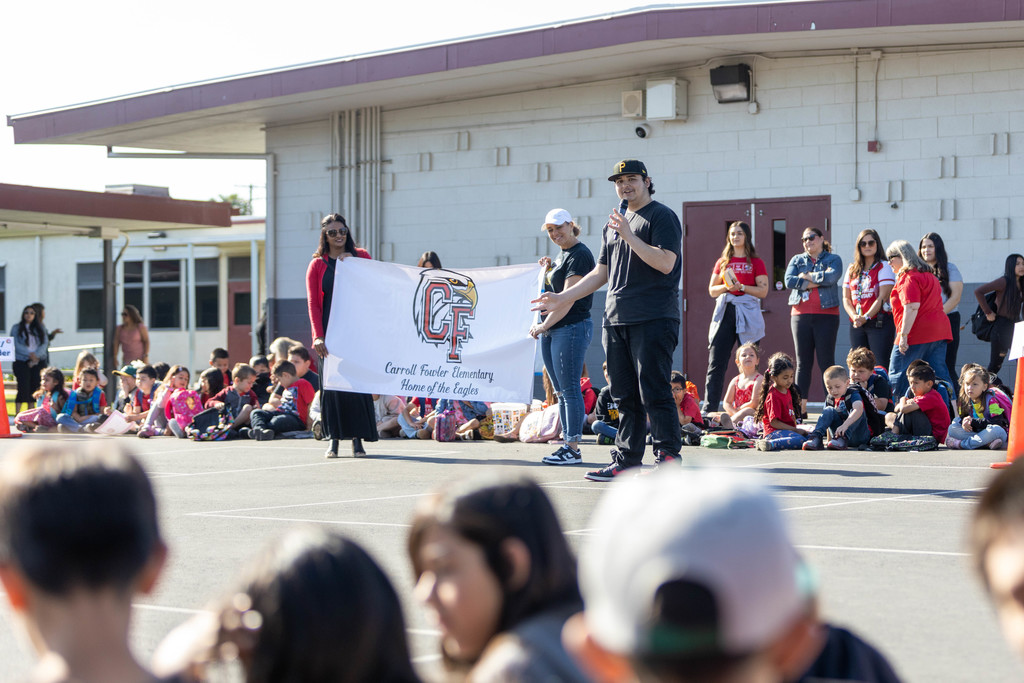 School assembly displaying new logo