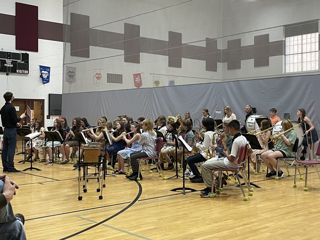 Students sitting in chairs playing band instruments