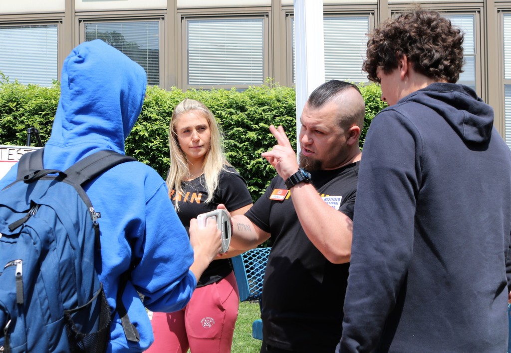 Personal trainers demonstrate a grip device with students