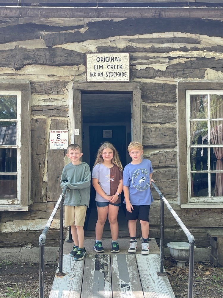 kids at a log cabin 