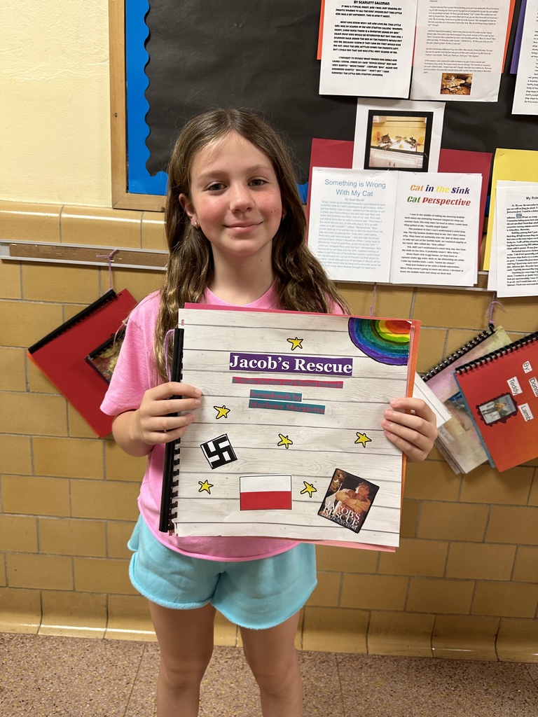 student holding their historical fiction scrapbook