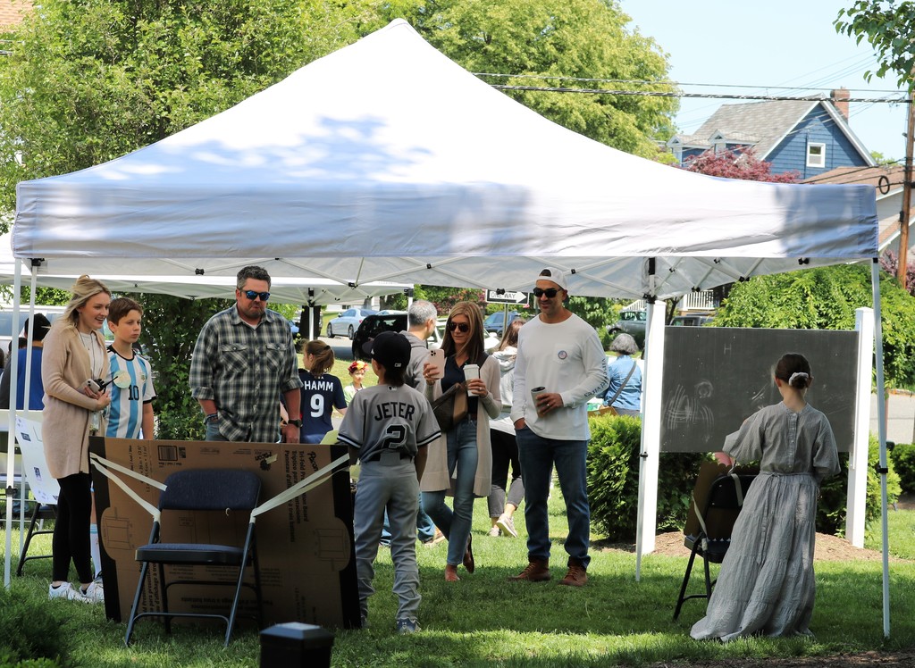 McKinley parents and staff listen to Wax Museum presentations by students under tent