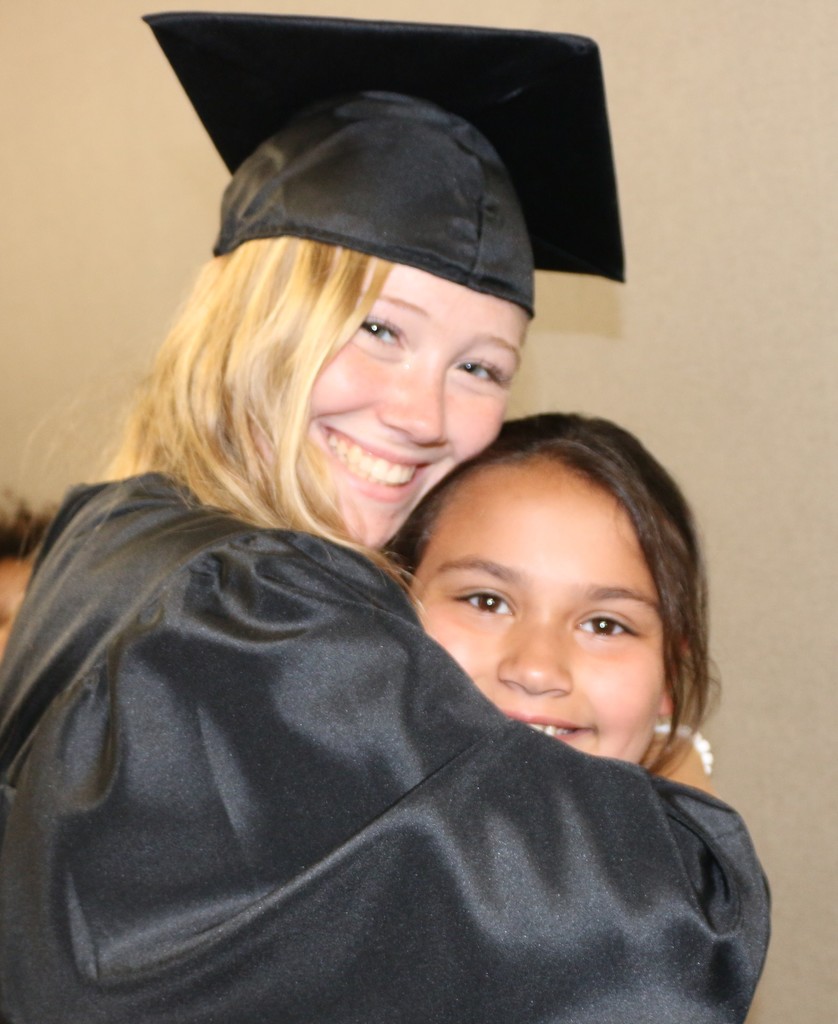 A senior gives a BPS student a hug during the Senior Walk
