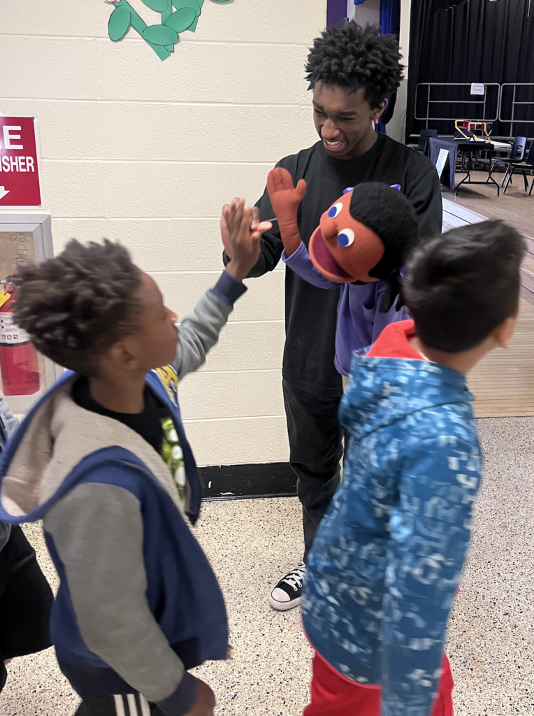 Puppet high fives student