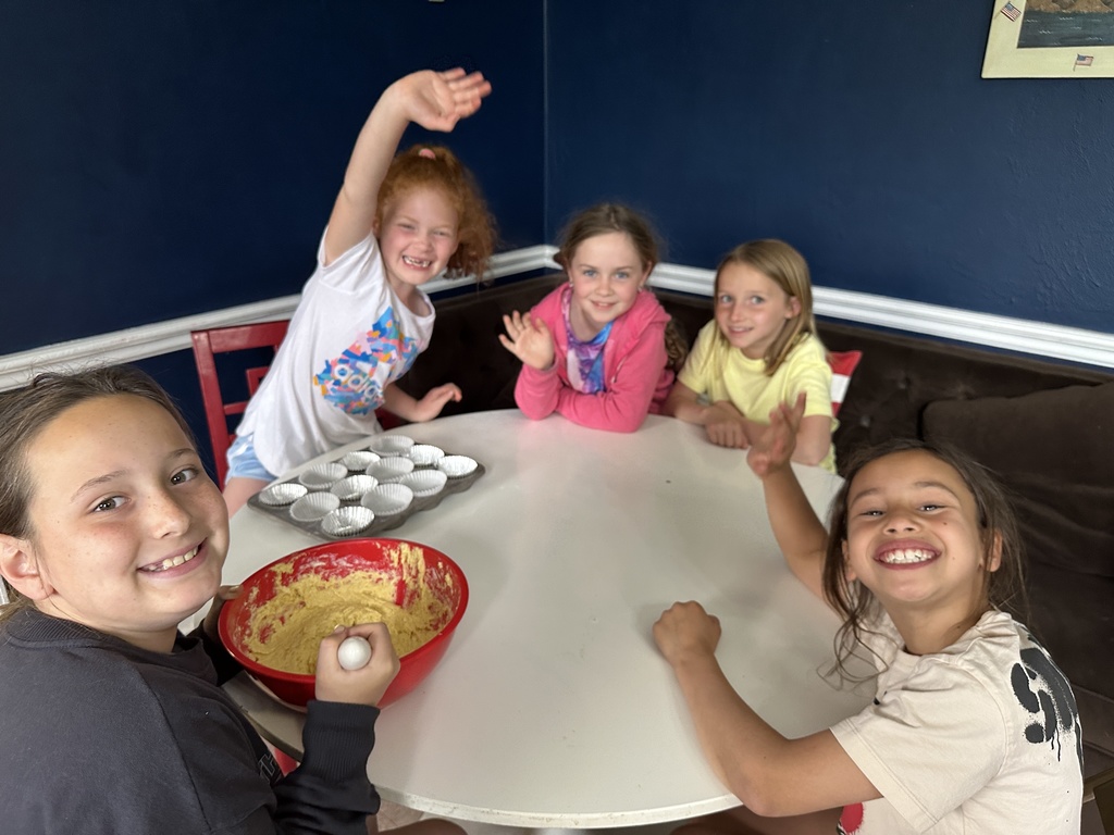 students from Cooking for Kids, working at a round table on muffins