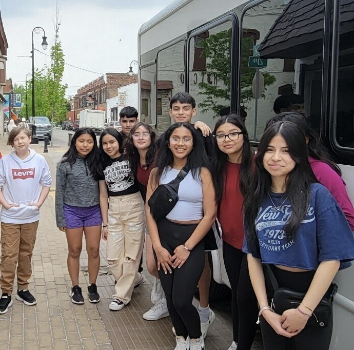 students stand by bus