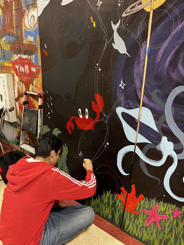 student works on mural