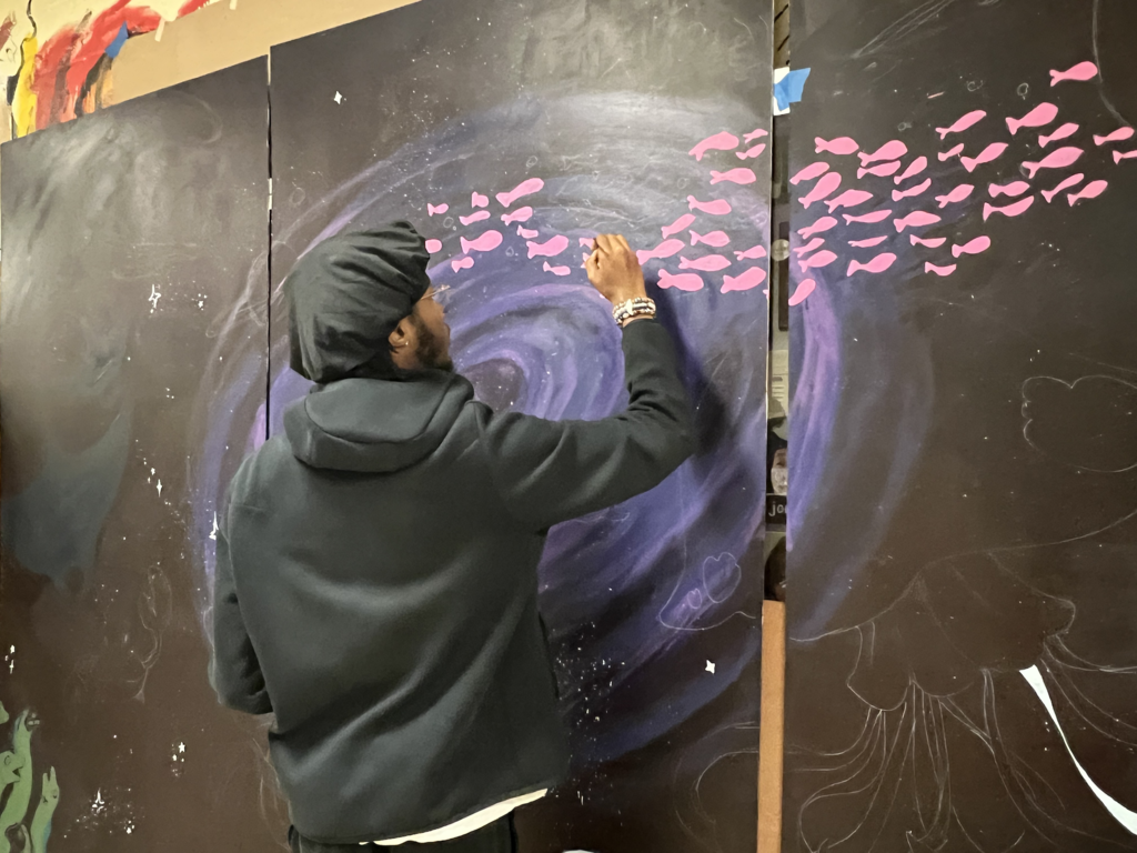 student works on mural