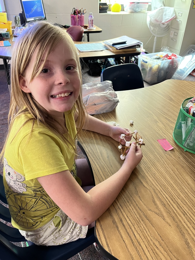 girl building structure out of marshmallows and toothpicks