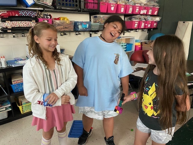 three girls holding a structure made of cubes