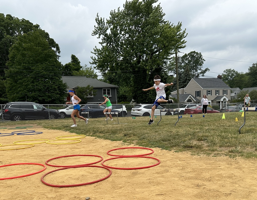 student jumping over hurdle during field day