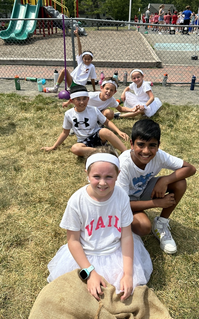 third grade students on the white team sitting during field day