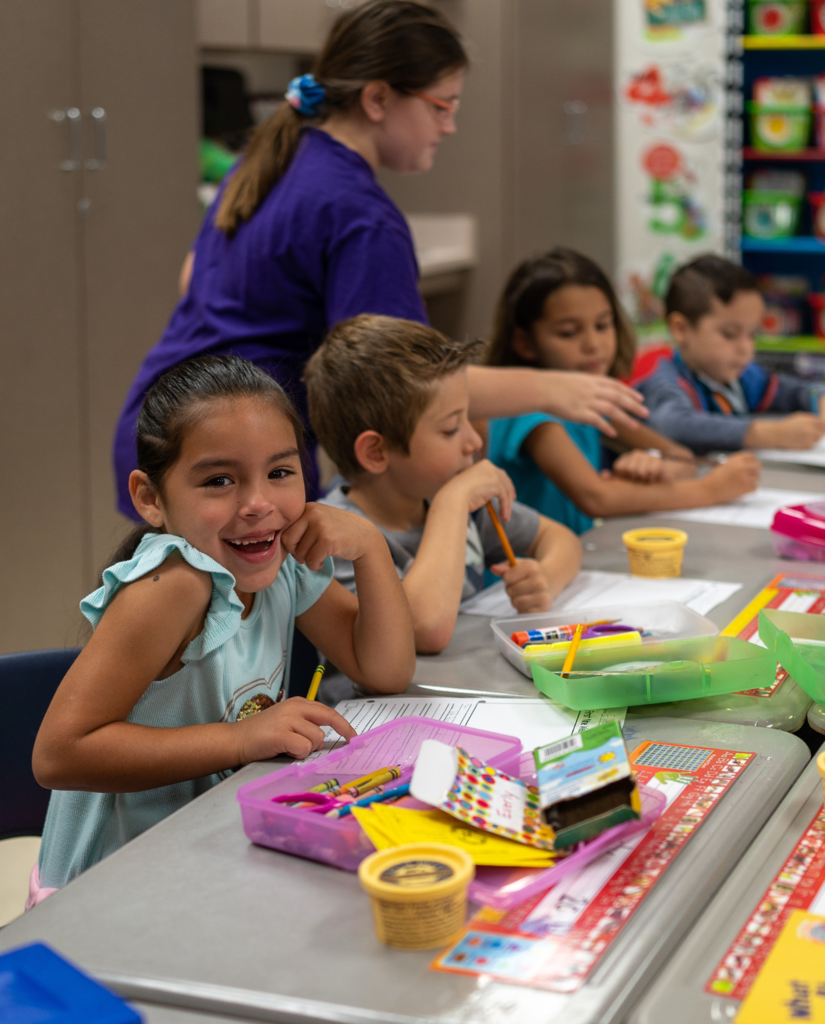 elementary age students coloring at a table