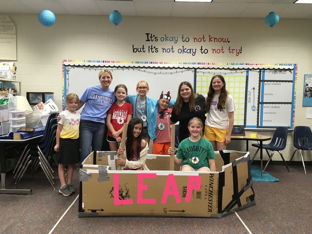 10 leap students posing with card board boat