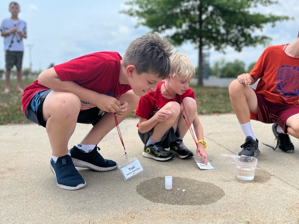 two boys look at their rocket